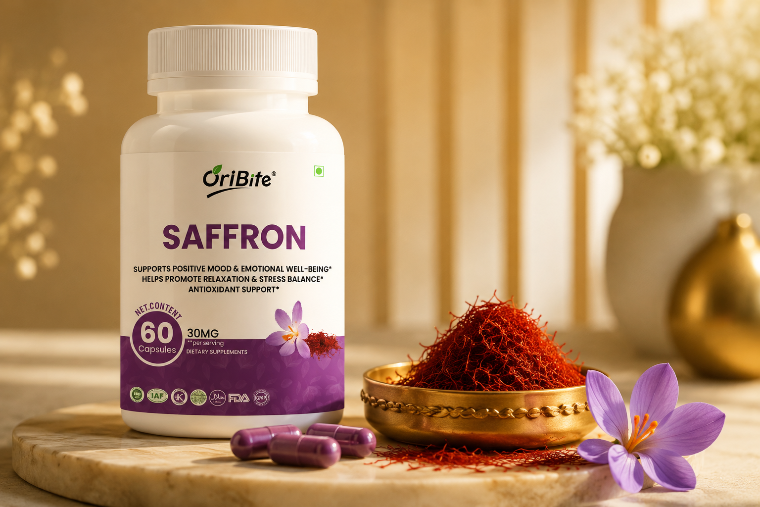 "A white bottle of Oribite Saffron Capsules on a wooden surface next to fresh purple saffron crocus flowers and a small wooden bowl piled with red saffron strands."