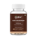 A clear plastic bottle of OriBite Cow Colostrum 1000mg dietary supplement with a white ribbed cap and a brown label, containing 60 chewable tablets visible at the bottom, on a white background.